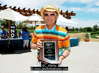 Photo of Glen Campbell with presentation for his induction in Arizona Music and Entertainment Hall Of Fame at the 9th Alice Cooper Golf Tournament in Scottsdale to benefit his Solid Rock Foundation Charity, May 2nd 2005. phoo by Chris walter/Photofeatures. , reference; DSC_4969a